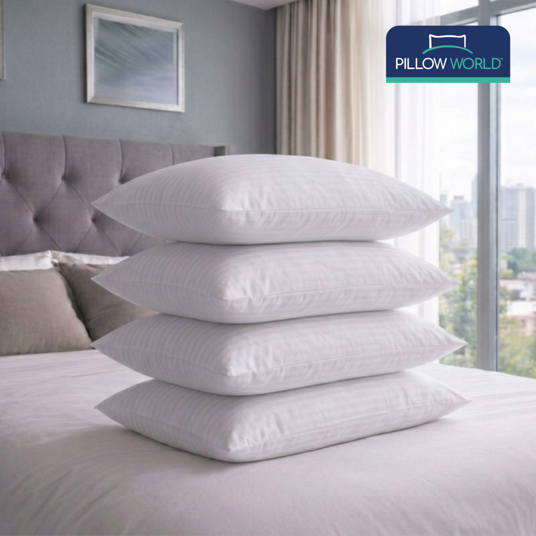 Four white striped pillows stacked on a bed in a modern bedroom, with a pillow world logo