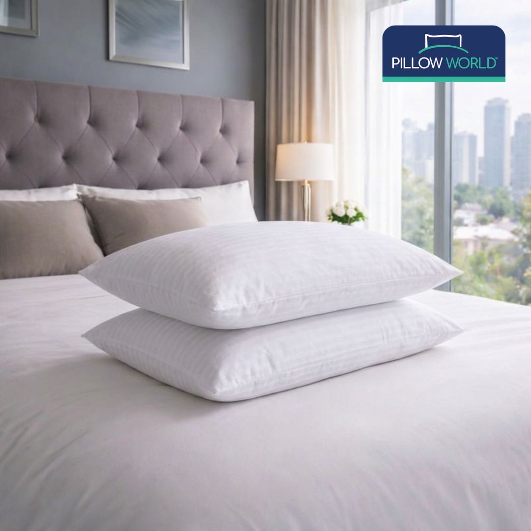 Two white pillows with striped covers on a bed. Hotel Luxury Pillow by Pillow World.